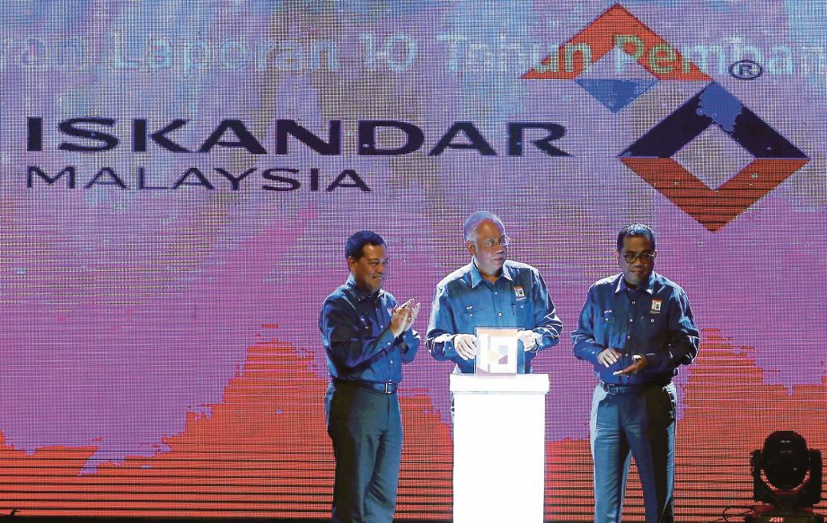 NAJIB  melakukan gimik pelancaran sambil diperhatikan  Mohamed Khaled  (kanan) dan  Ismail sempena sambutan Ulang Tahun ke-10 Iskandar Malaysia (IM10) di Kompleks Sukan Educity, semalam. 