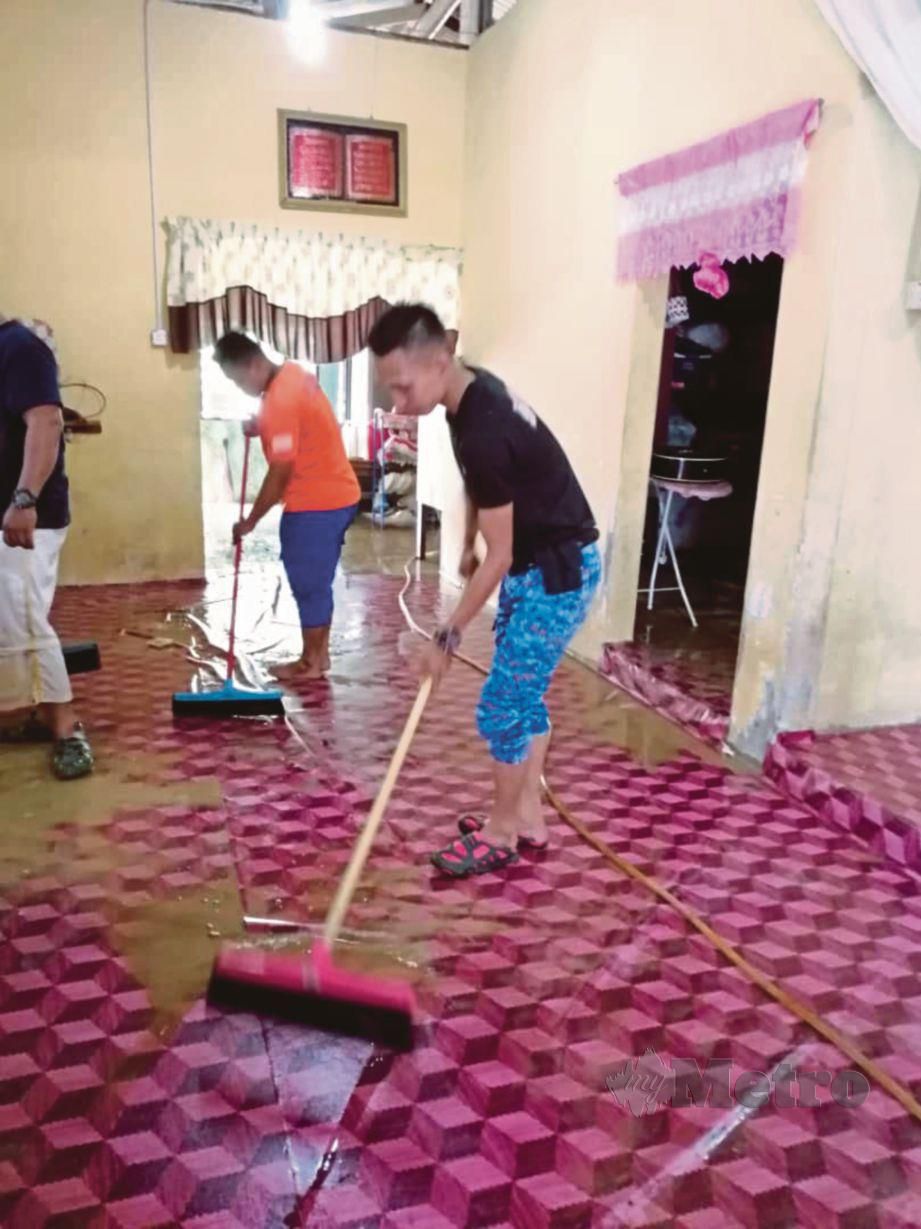 ANGGOTA APM membantu membersihkan rumah mangsa banjir.