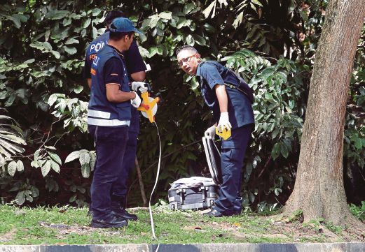 ANGGOTA polis membuat pemeriksaan mayat yang disumbat di dalam beg.