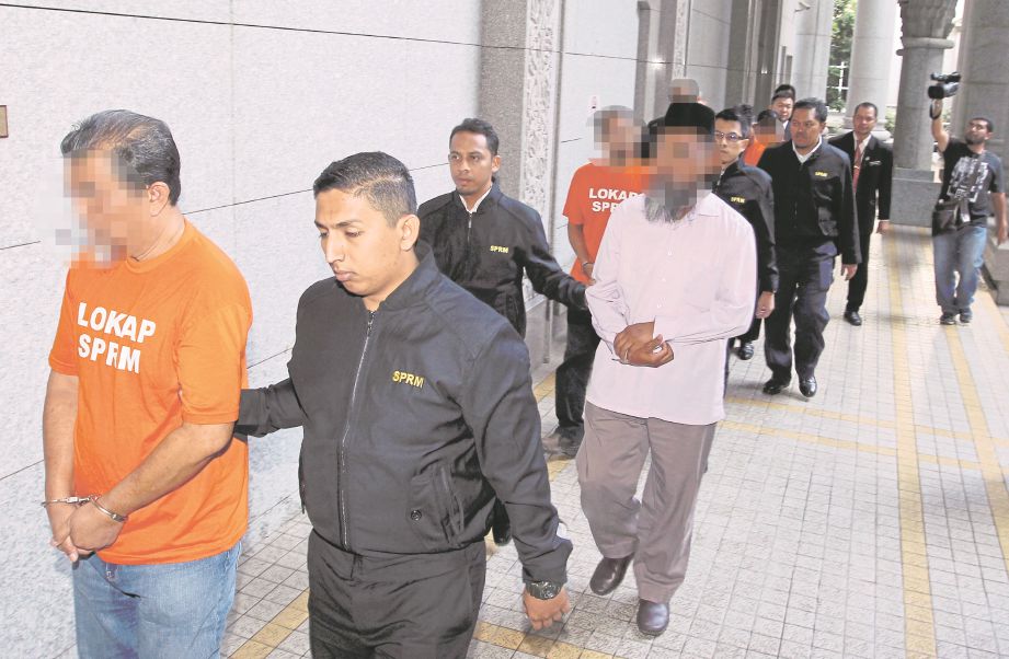 ANGGOTA SPRM mengiringi enam  lelaki di Mahkamah Majistret Putrajaya, semalam. 