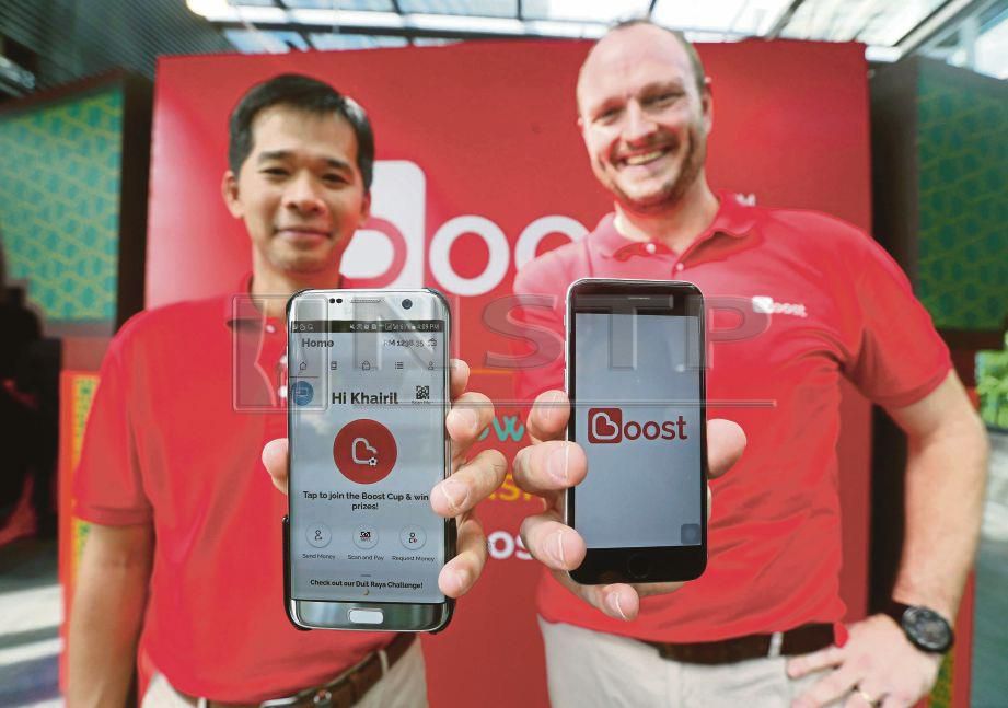 MOHD Khairil (kiri) menunjukkan e-dompet Boost di Kuala Lumpur.