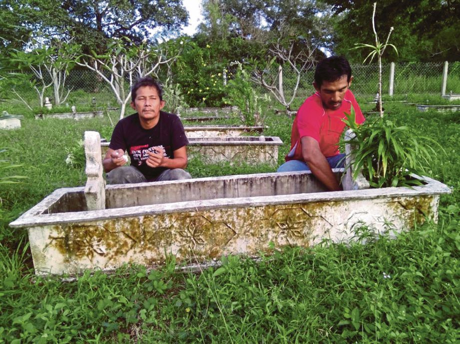 ROSLIN membersihkan kawasan  kubur ibunya,  Mariam Jusoh manakala Mohamad Zamri membacakan doa buat arwah ibu saudaranya di Tanah Perkuburan Kampung Baru Kuala Abang.