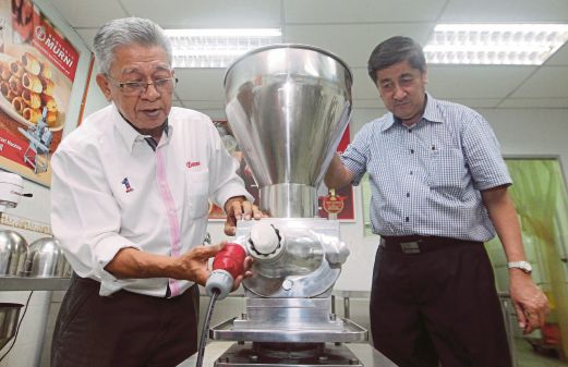LIM (kanan) dan Pengarah Komunikasi Korporat & Perhubungan Murni Bakery Equipment Sdn Bhd, Saiden Osman memeriksa mesin memproses kuih dan biskut.