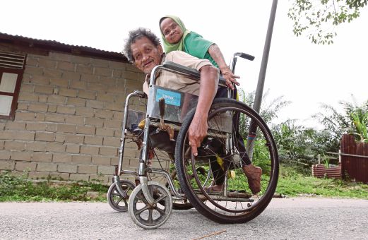HASSAN dan Noriah sentiasa bersama ke mana saja walaupun menggunakan kerusi roda. 