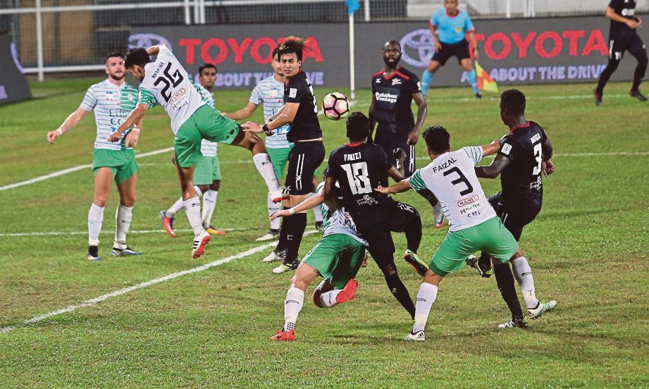 PEMAIN T-TEAM  Fauzi Abdul Kadar (tiga kanan) cuba menanduk di hadapan pintu gol sambil diasak pemain Melaka.