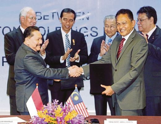 ABDUL Harith (kanan) bertukar dokumen MoU dengan Abdullah Mahmud bagi pembangunan dan pembuatan kereta nasional Indonesia. 