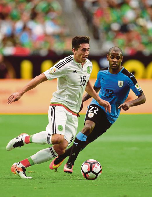 HERRERA (kiri) bersaing dengan pemain Uruguay Diego Rolan pada perlawanan, semalam.