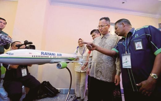 RAVI (kanan) memberi penerangan kepada Mohd Rawi mengenai Boeing 737 400 yang akan memulakan operasinya pada hujung bulan ini. 