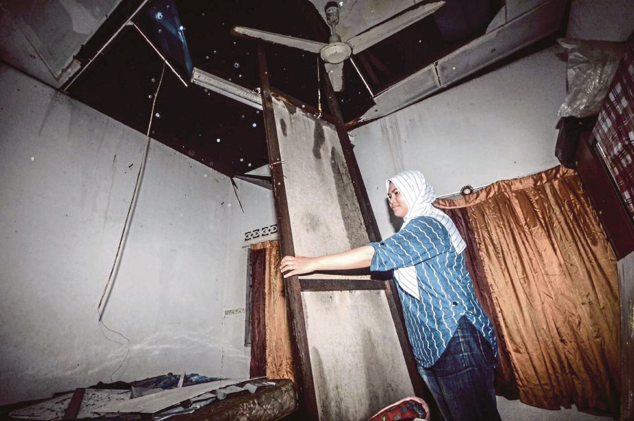 Nurul Qurratul Ain  melihat bumbung rumahnya yang  tercabut.