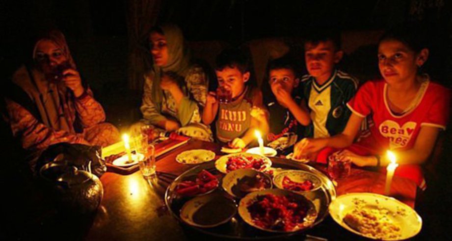 SEBUAH keluarga Palestin makan malam dengan hanya menggunakan cahaya lilin kerana tidak mendapat bekalan elektrik.  - Agensi 