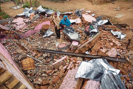 PENDUDUK kampung mencari sisa barangan yang  boleh digunakan selepas rumah mereka ranap terkena bedilan bom di Bainglar, Jammu. 