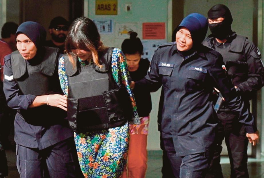  Doan  (kiri) dan  Siti Aisyah  diiringi anggota polis selepas menghadiri perbicaraan  di Mahkamah Tinggi, Shah Alam, semalam.