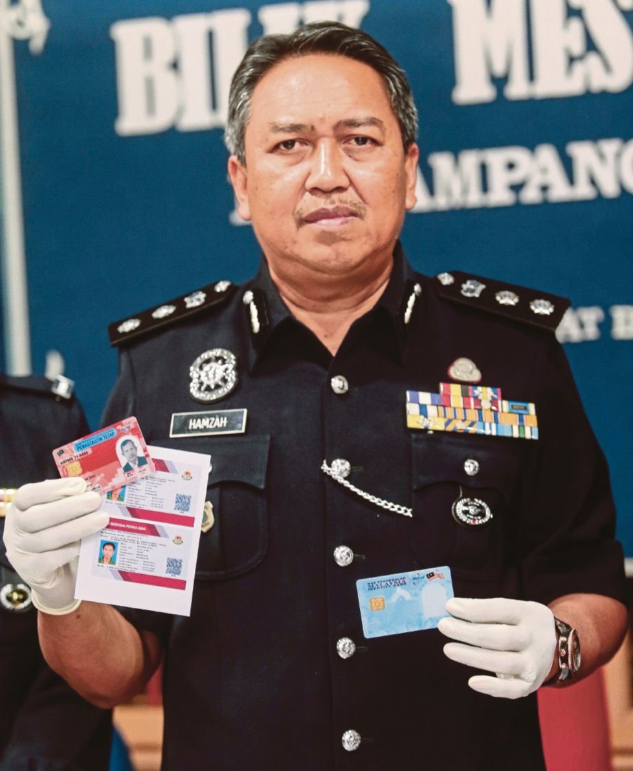 Hamzah menunjukkan kad pengenalan palsu yang dicetak kumpulan sindiket ketika sidang media  di IPD Ampang Jaya, semalam.