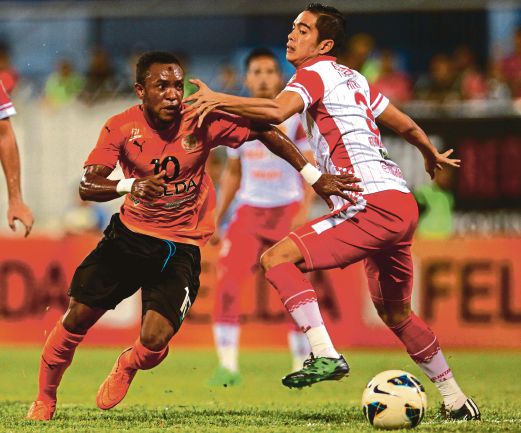 PEMAIN FELDA, Zah Rahan Krangar (kiri) melepasi halangan pemain Kelantan, Mohd Fitri Omar.   