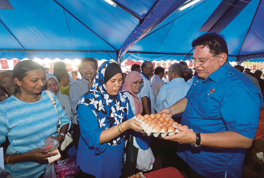 TENGKU Adnan membantu jualan ketika Program Jualan Sentuhan Rakyat Putrajaya di Presint 2, Putrajaya.
