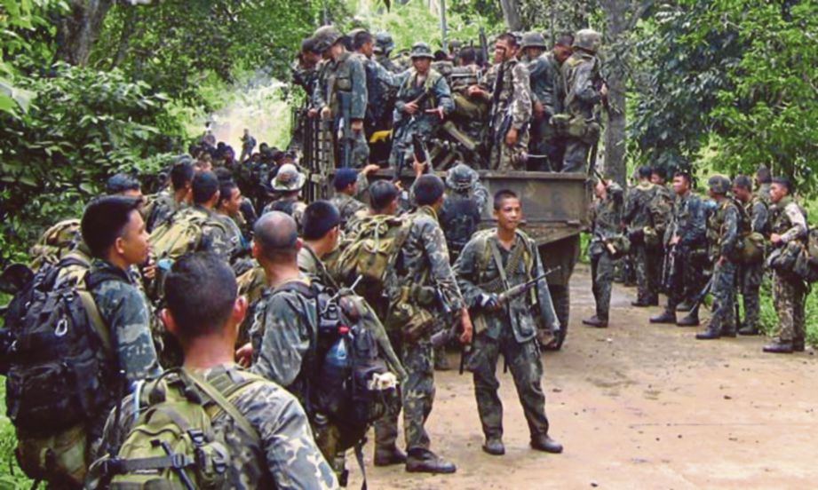 ASKAR Filipina turun dari trak dalam satu operasi memburu militan Abu Sayyaf berhampiran Patikul di Pulau Jolo. FOTO Agensi