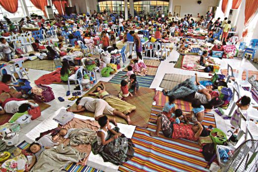RATUSAN penduduk berlindung di sebuah dewan di bandar Surigao, tengah Filipina, semalam   untuk  berlindung daripada Taufan Hagupit.