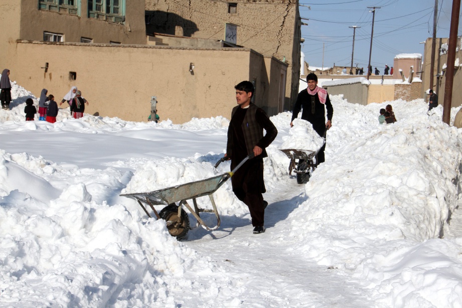 PENDUDUK kampung di Ghazni, Afghanistan membersihkan kawasan kediaman mereka daripada salji tebal yang melanda negara itu sejak tiga hari lalu.  - EPA 