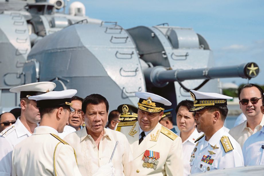 DUTERTE (tiga dari kiri) berbual dengan pegawai tentera laut Russia ketika melawat kapal antikapal selam negara itu di Manila, semalam.   - AFP