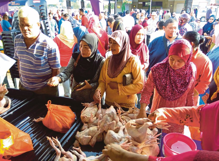 ORANG ramai berebut-rebut membeli ayam dan  ikan yang dijual pada harga murah di SJKC Lum Hua,   semalam.