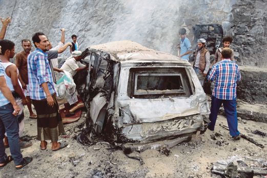PENDUDUK Yaman melngerumuni kereta yang musnah selepas ia digunakan untuk membunuh Gabenor Aden. 
