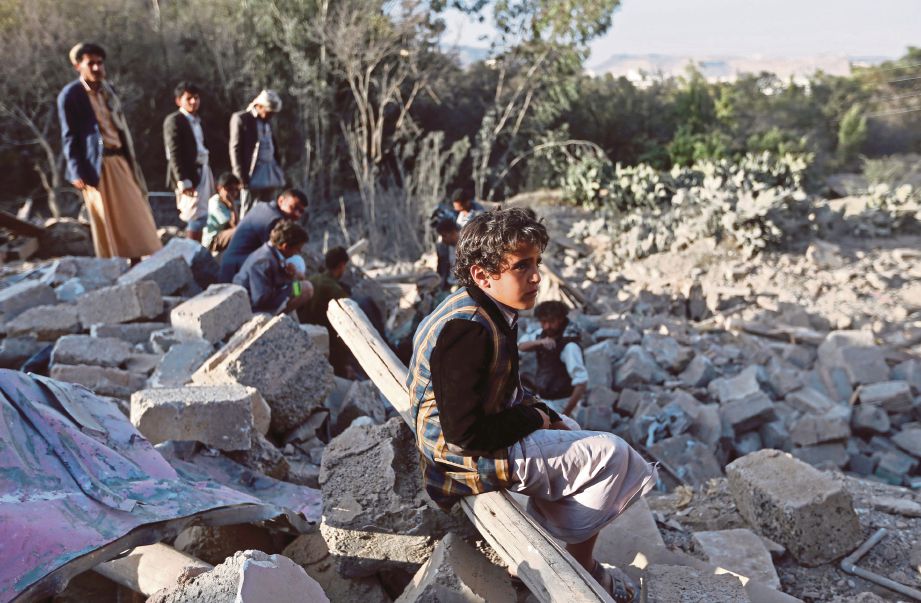 SEORANG kanak-kanak lelaki memandang ke arah  rumahnya yang musnah akibat perang saudara yang tercetus di Yaman sejak dua tahun lalu.