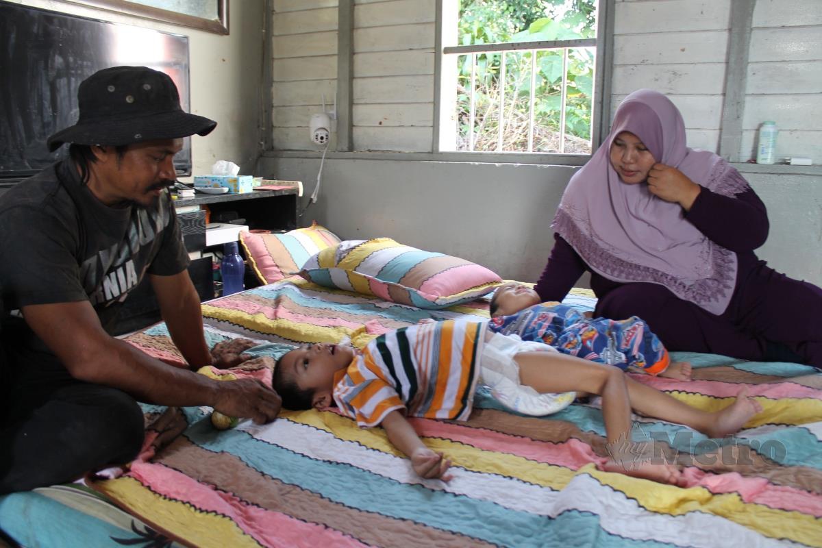 Noorakmar Mahmood dan suami di sisi kedua-dua anak istimewa mereka ketika ditemui di rumah mereka di Kampung Batu Rembau. Foto Mohd Amin Jalil