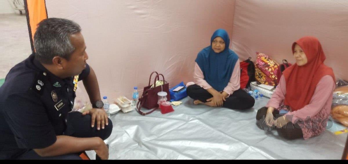 Ketua Polis Daerah Baling, Superintendan Shamsudin Mamat melawat mangsa banjir di Pusat Pemindahan Sementara (PPS) Dewan Tun Abdul Razak, yang dibenarkan pulang, hari ini. FOTO SAFURI KAMARUDIN