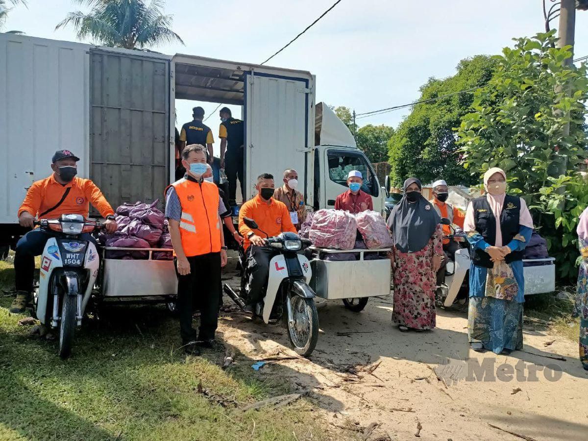 Agihan bakul makanan dibuat oleh sukarelawan menggunakan motosikal roda tiga ke 250 rumah di Kampung Belian, di sini yang dikenakan PKPD bermula semalam hingga 17 Ogos ini. FOTO SITI ROHANA IDRIS