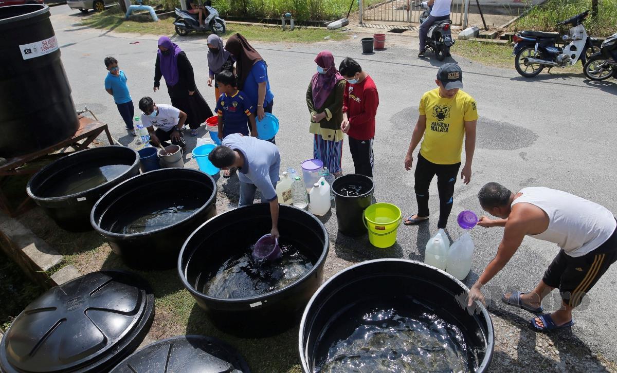 Penduduk di Taman Desa Tanjung Damai, Gong Badak mengambil air susulan gangguan bekalan air sejak semalam.  FOTO GHAZALI KORI 