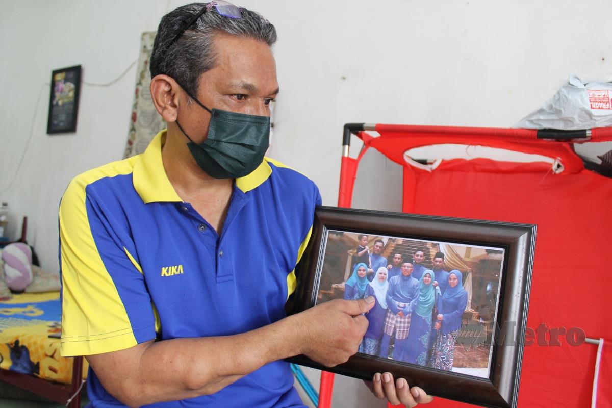 Shahrizal menunjukkan gambar arwah isteri Norhaliza Hussin dengan ahli keluarganya ketika ditemui di rumahnya di Senawang, hari ini. FOTO Mohd Amin Jalil