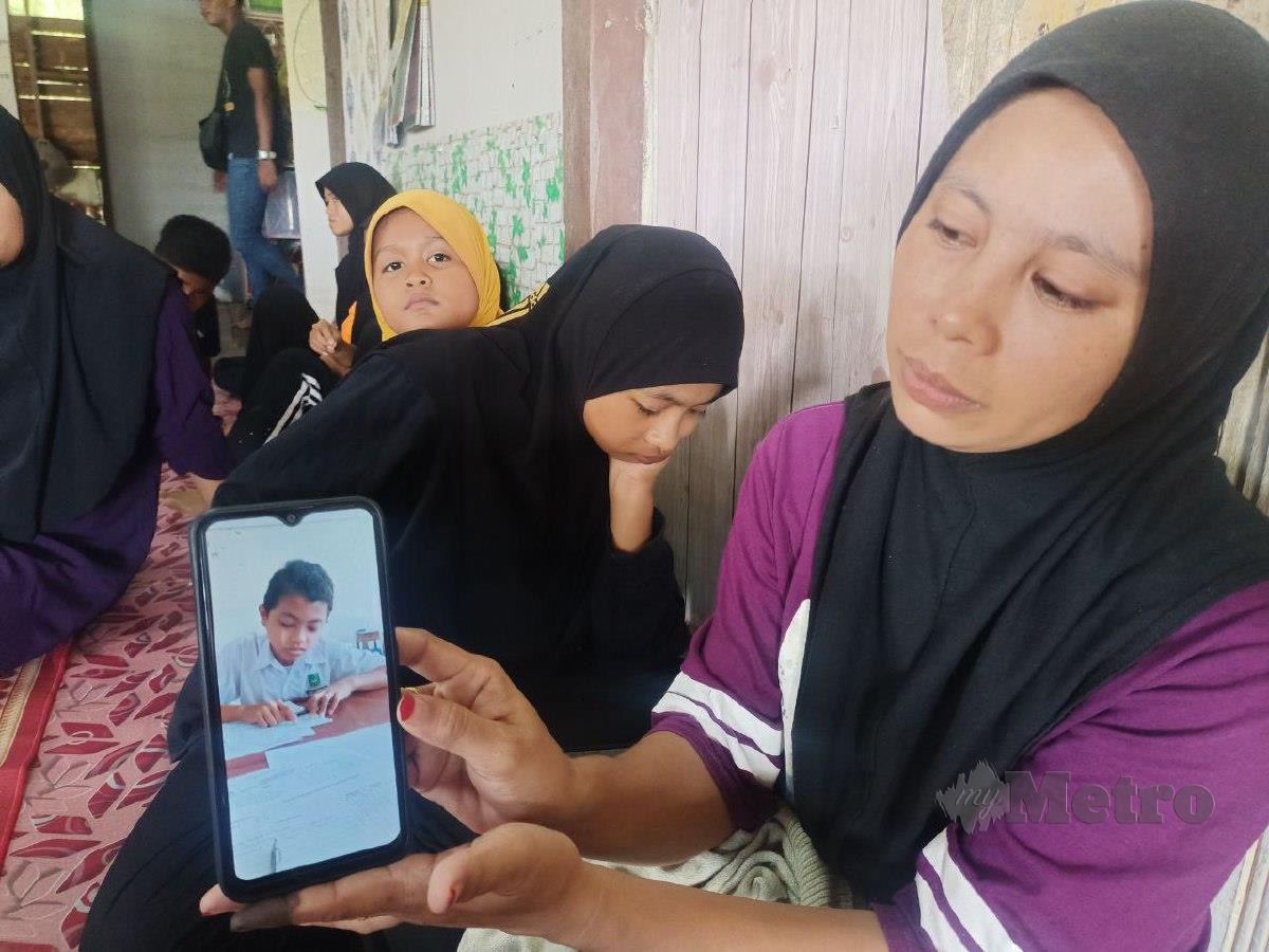 Noridawati Ismail, 33, menunjukkan foto Muhammad Aidil Zaquan Abdullah, 13, yang ditemukan lemas di tali air di Kampung Kubang Sawa, Pengkalan Kubor ketika cuba menyelamatkan dua sepupunya yang nyaris lemas petang semalam. FOTO SITI ROHANA IDRIS