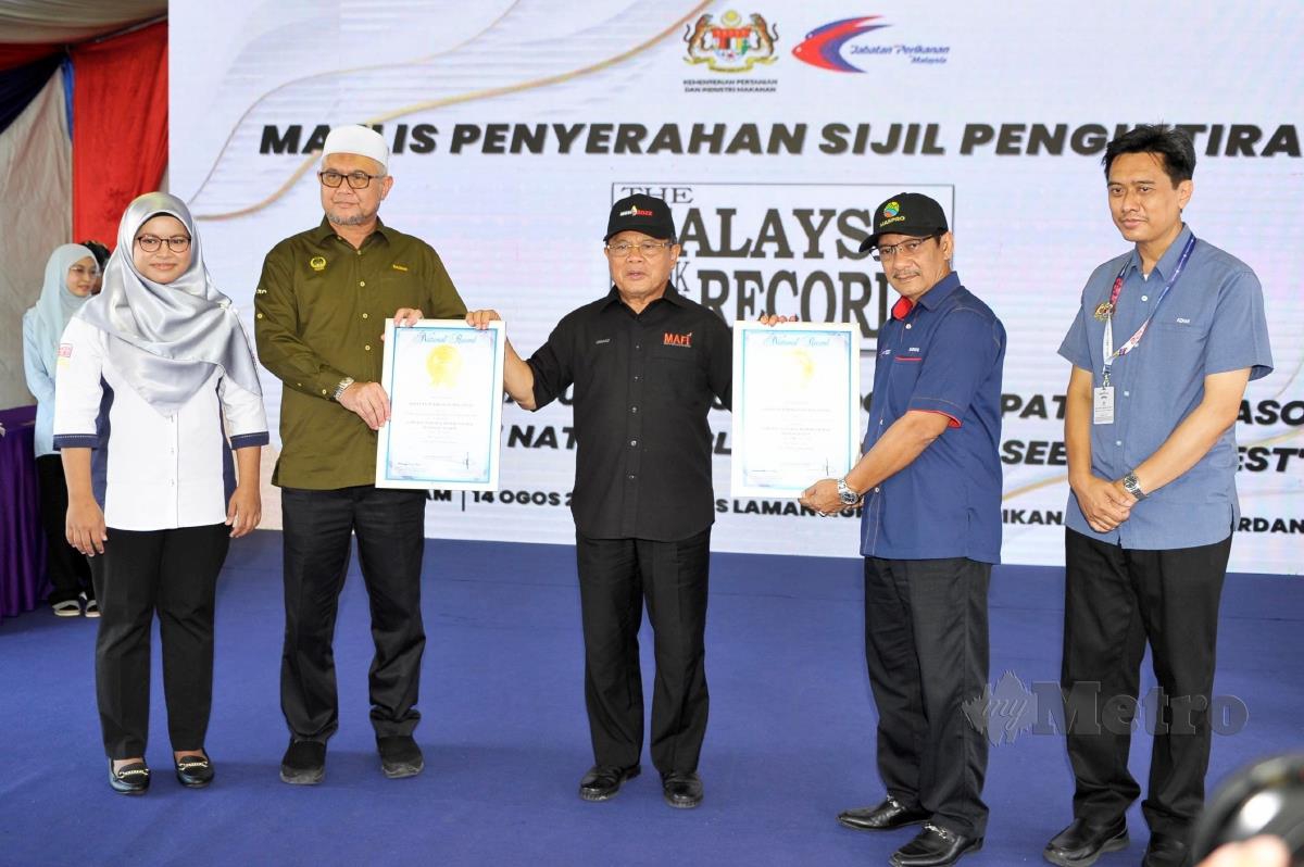 Datuk Seri Dr Ahmad Hamzah (tengah) menunjukkan sijil MBOR bagi musim kejatuhan benih semulajadi kerang terpanjang (18 bulan) dan pendaratan benih kerang semulajadi terbesar (1,300 Metrik Tan)  pada Majlis Penyampaian Sijil Malaysia Book Of Record (MBOR) sempena Pameran Pertanian, Hortikultur dan Agropelancongan Malaysia (MAHA) 2022 di Taman Ekspo Pertanian Malaysia (MAEPS), Serdang. FOTO AIZUDDIN SAAD