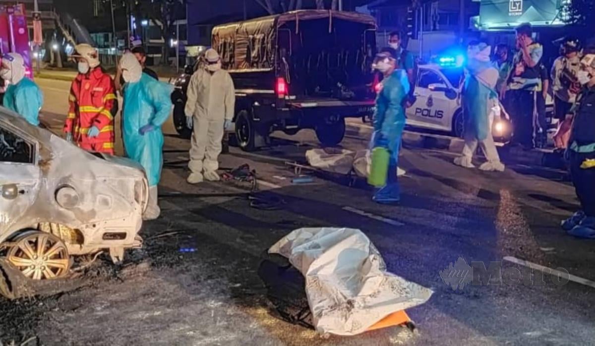 Anggota bomba mengeluarkan mayat tiga mangsa rentung selepas kenderaan yang mereka naiki terbakar dalam satu kemalangan di Jalan Masjid Negeri, di sini. FOTO IHSAN JBPM