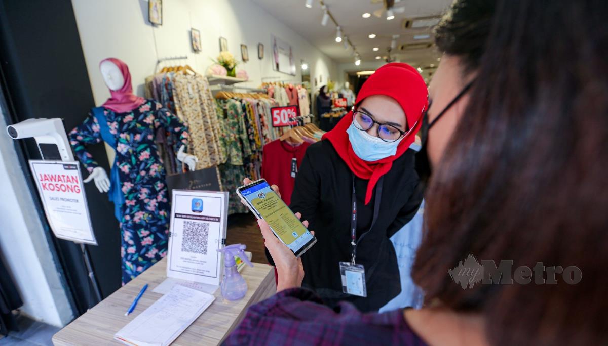 Pekerja kedai pakaian, Noor Shazwani Shahrom Badrol Hisham, 25 melihat sijil digital vaksinasi COVID-19 yang ditunjukkan oleh pelanggannya sebelum dibenarkan masuk ke premis pada tinjauan individu yang telah menerima vaksinasi lengkap dua dos bagi negeri-negeri di Fasa 1 Pelan Pemulihan Negara (PPN) dibenarkan masuk ke premis seperti kedai makan, restoran dan pusat beli-belah di sekitar ibu negara . FOTO ASWADI ALIAS