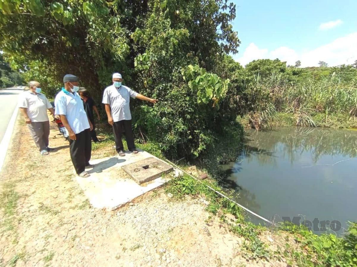 Penduduk Kampung Batang Rokan menunjukkan keadaan Sungai Air Salak yang berwarna hitam didakwa akibat pencemaran dari ladang penternakan ayam berhampiran. FOTO ABNOR HAMIZAM