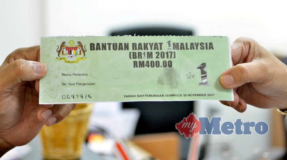 PENERIMA menyerahkan baucar Bantuan Rakyat 1 Malaysia (BR1M). FOTO Faiz Anuar