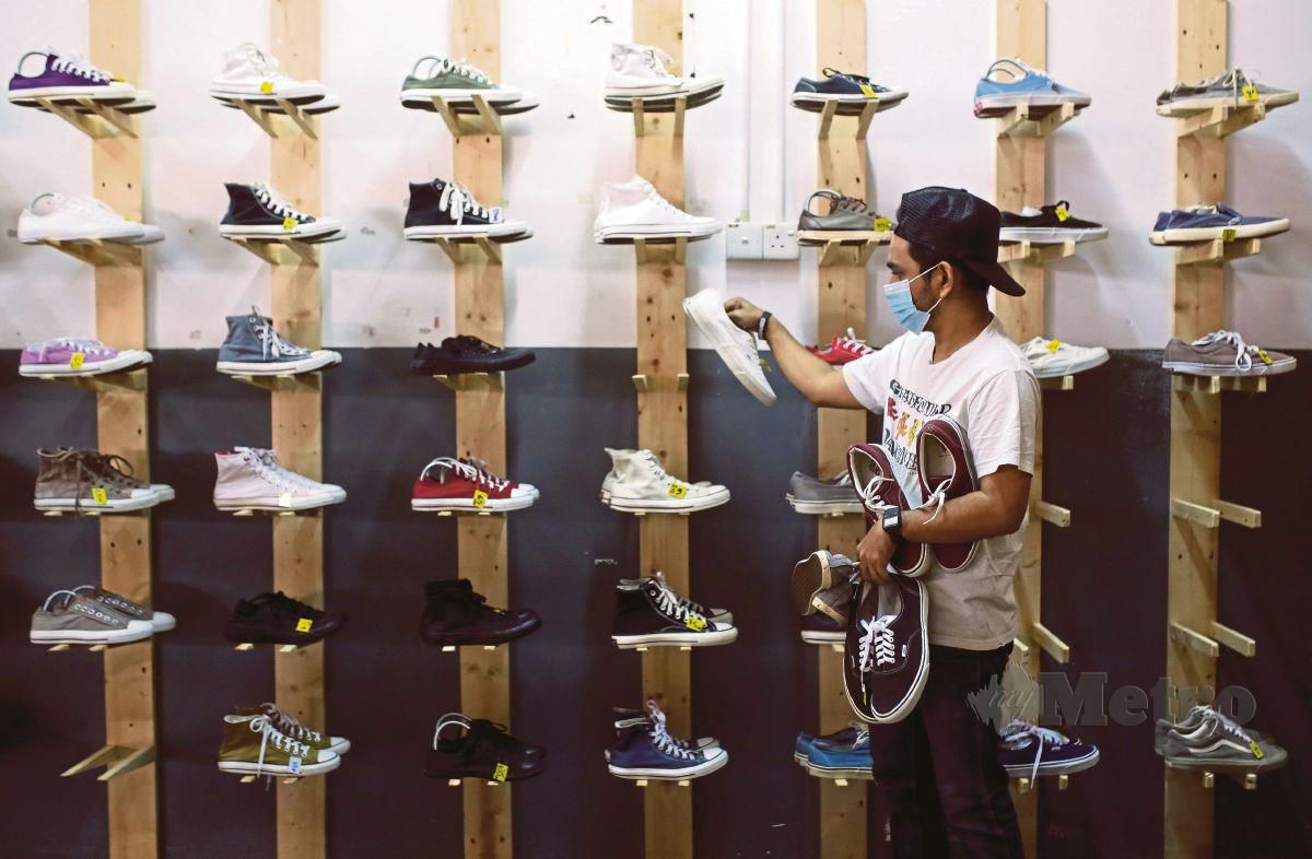 PENIAGA kasut terpakai, Hasbi Sidek menyusun pelbagai jenis sepatu yang akan dijual kepada orang ramai ketika tinjauan di kedainya di Lavender Height, Seremban. MIDF Research mengunjurkan pertumbuhan ekonomi Malaysia untuk kembali pulih dan berkembang sebanyak tujuh peratus pada tahun ini. 