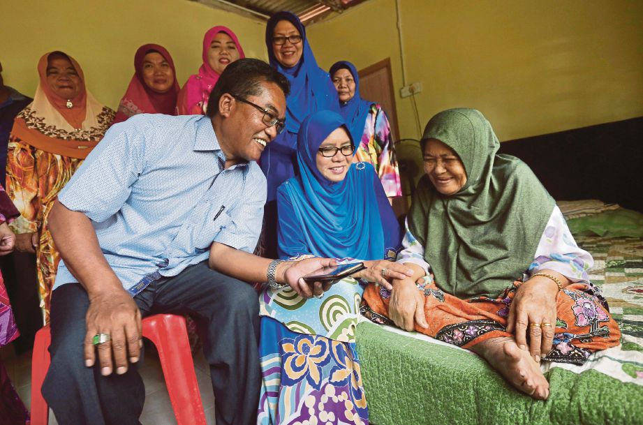 A Latiff bersama isteri, Norlia Harun (dua kiri) meluangkan masa melawat warga emas Noraizan Salleh, 64 di Kampung Durian Guling. 