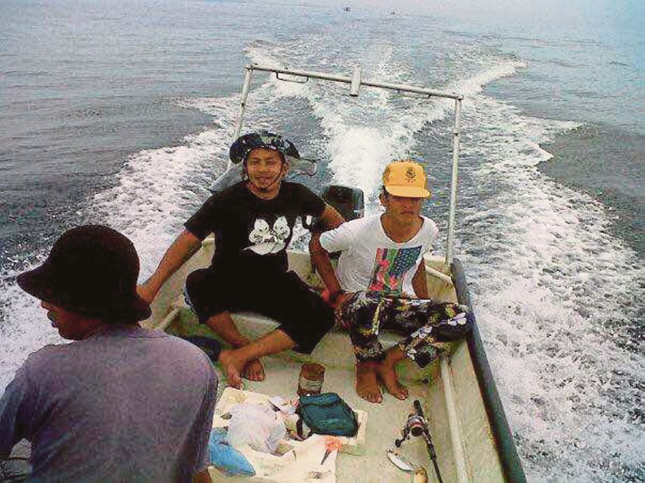 Mohd Shukri (tengah) membawa bot untuk mencari ikan.