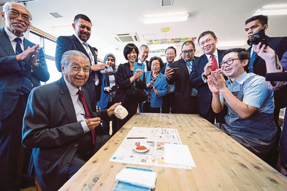 DR Mahathir  menunjukkan lencana tertera nama Kedah hasil tangan beliau ketika melawat kelas seramik di Sekolah Rendah Ritsumeikan sempena lawatan kerja ke Kyoto, semalam. FOTO BERNAMA
