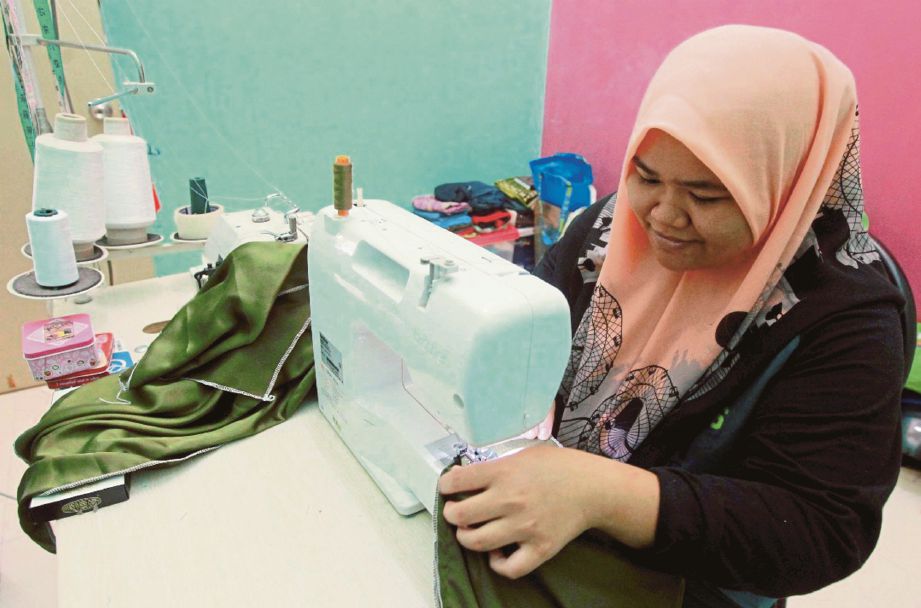  NUR Amiera  menyiapkan tempahan baju raya yang diterima di rumahnya  di Perumahan Bukit Rangin Perdana.