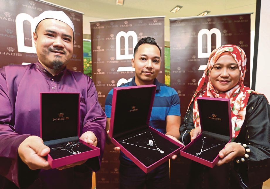 Wakil Khairunnissa,  Abd Khaliq Azman (tengah) bersama Nor Azilah Maarof (kanan) dan  Mohd Rafiq menunjukkan  hadiah.