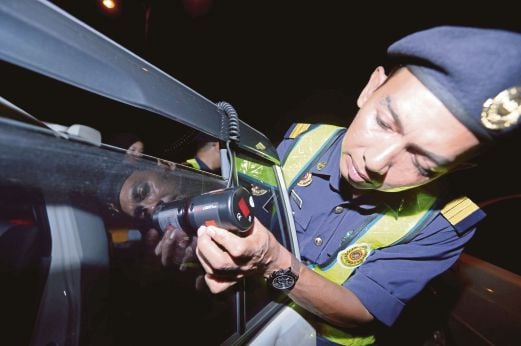 ANGGOTA penguat kuasa JPJ memeriksa ketelusan cahaya pada cermin kenderaan dalam operasi di Jalan Langgar.