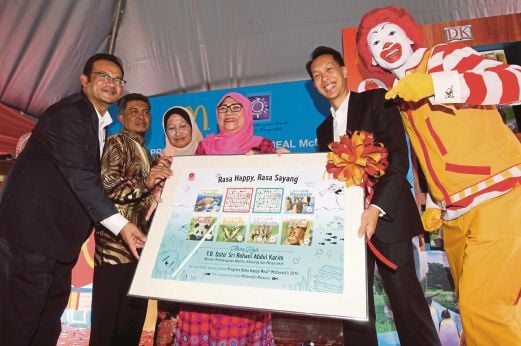 Rohani (empat dari kiri) menerima cenderamata daripada Chew (dua dari kanan) selepas merasmikan buku Happy Meal McDonald’s.