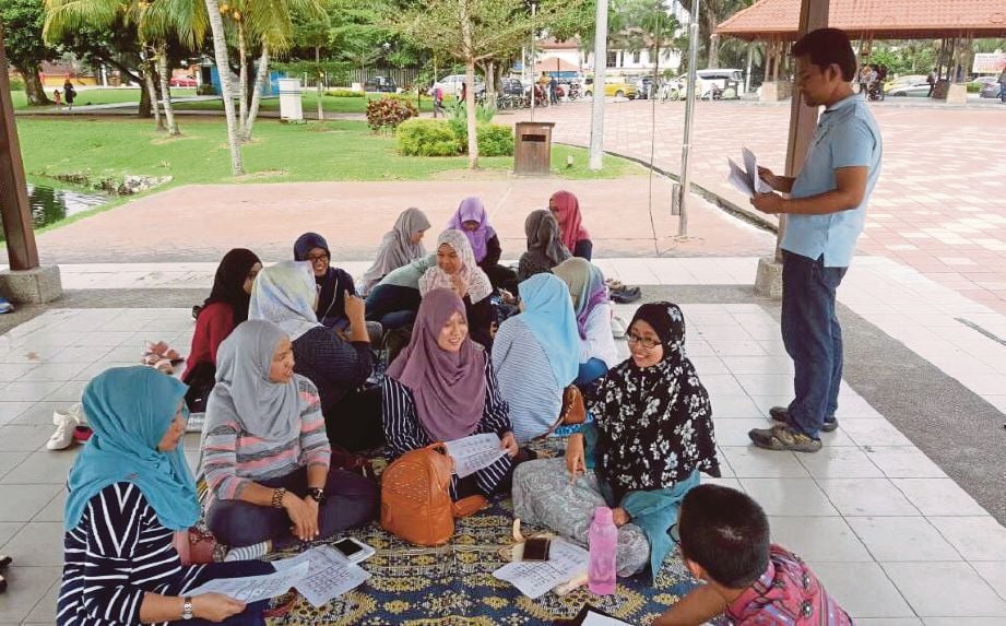 Mohd Armi   mengajar bahasa isyarat kepada orang ramai di Tasik Titiwangsa.