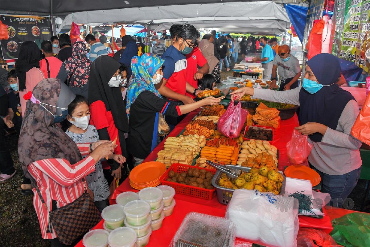 ORANG ramai  mematuhi prosedur operasi standard (SOP) dengan memakai  pelitup muka ketika melakukan aktiviti menjual dan membeli juadah  di Bazar Taman Suria, Johor Bahru, semalam. 