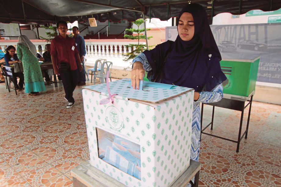 SEORANG wanita memasukkan kertas undi di dalam peti ketika mengundi dalam pungutan suara di wilayah Pattani, Thailand, semalam. - Reuters