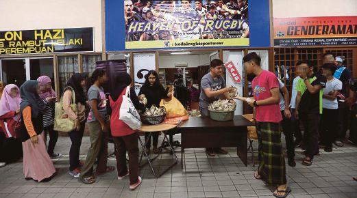  Sukarelawan mengagihkan makanan kepada mahasiswa   yang kurang berkemampuan    membeli makanan. 