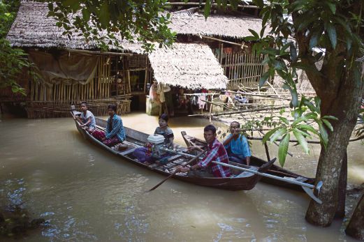 PENDUDUK di kampung Kyouk Tain di wilayah Irrawaddy menggunakan sampan untuk berpindah ke tempat lebih selamat selepas kediaman mereka dinaiki air.